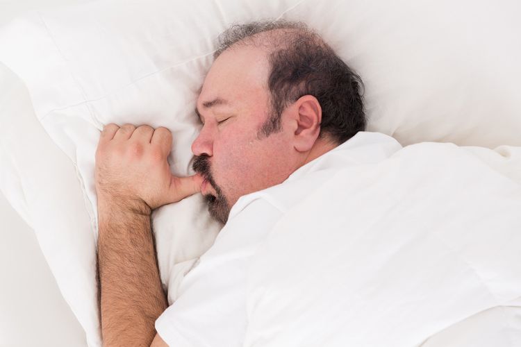 Photo of a adult man with sucking thumb and sleeping in bed