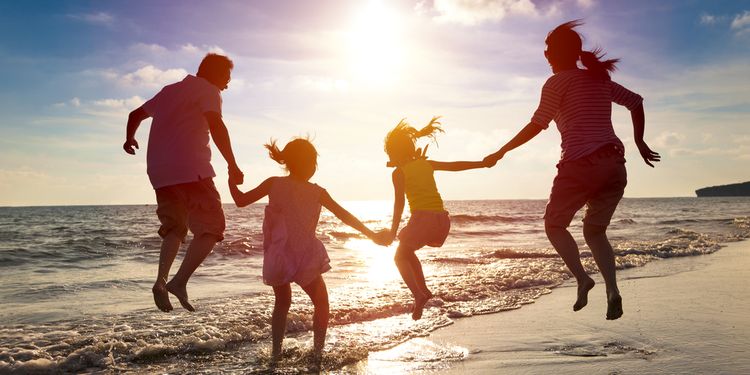 Photo of happy couple with kids on beach
