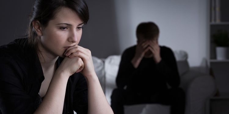 Photo of worried young couple in dark room