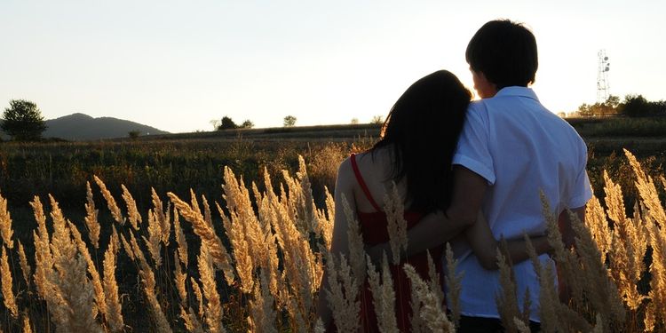 Photo of couple hugging in tall grass