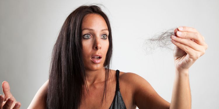 Photo of woman holding her lost hair